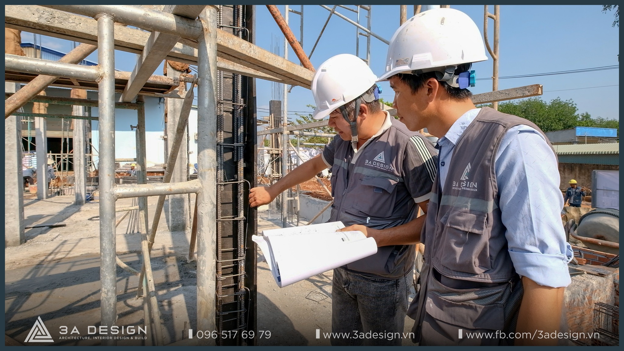 Hai kỹ sư 3A Design đội mũ bảo hộ, kiểm tra chi tiết kết cấu thép tại công trường, tay cầm bản vẽ kỹ thuật để đảm bảo thi công đúng tiêu chuẩn.