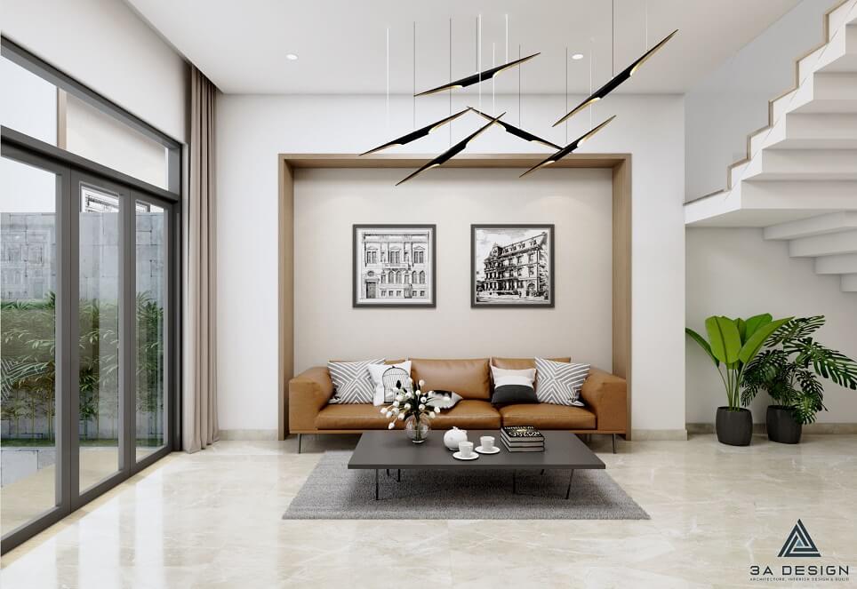 Phòng khách nhà phố với sofa nâu đất, tường trắng và điểm nhấn tranh đen trắng.