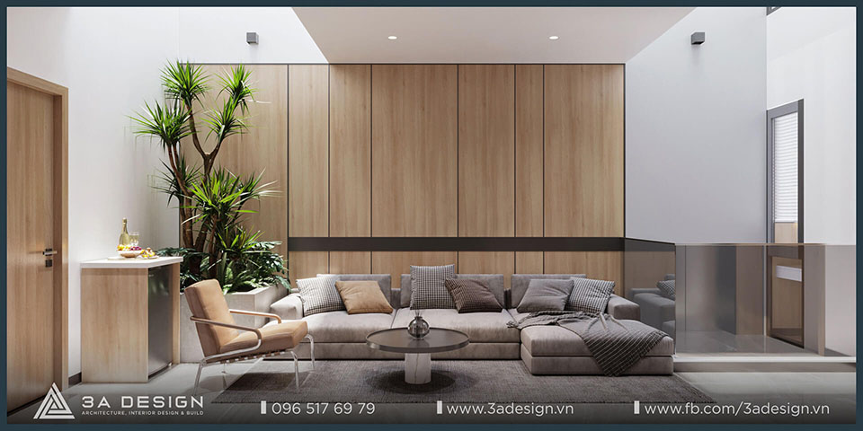 Phòng sinh hoạt chung phong cách Tropical với sofa rộng, mảng tường gỗ sáng, cây xanh nội thất và giếng trời đổ ánh sáng tự nhiên.