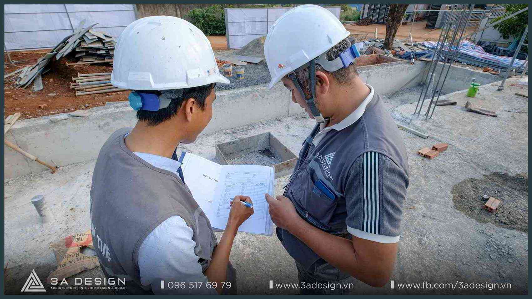 Hai kỹ sư 3A Design đội mũ bảo hộ đang kiểm tra hồ sơ và bản vẽ thi công trực tiếp tại công trình, đảm bảo chất lượng và tiến độ theo tiêu chuẩn kỹ thuật.