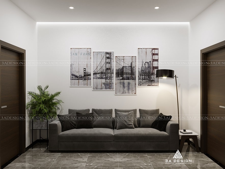 Phòng khách tối giản với sofa xám, bộ tranh treo tường, và đèn sàn hiện đại.