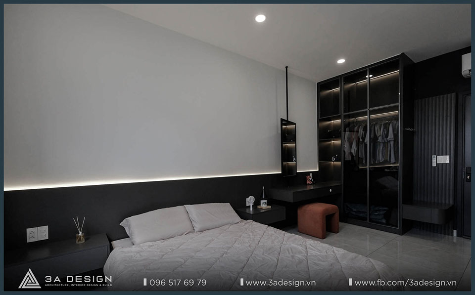 Phòng nổi bật với gam màu tối, giường ngủ có đèn hắt sáng và tủ quần áo kính sang trọng.