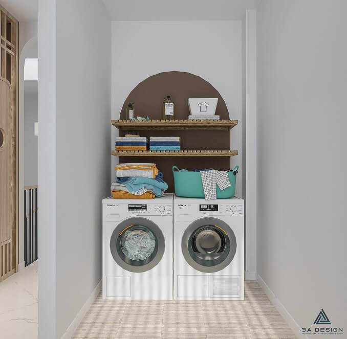 Khu vực giặt đồ nhỏ gọn, có hai máy giặt, kệ gỗ treo tường, giỏ đựng đồ màu xanh ngọc lam, và sàn lát gạch sáng.