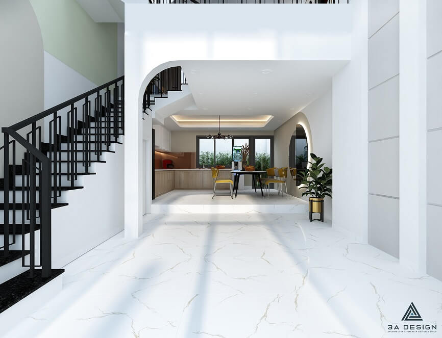 Phối cảnh Tầng Trệt nhà phố hiện đại, tập trung vào cầu thang màu đen-trắng và không gian mở dẫn vào khu vực bếp/ăn ở phía sau với vòm cong kiến trúc.